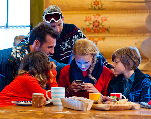 Family in cabin looking at smartphone